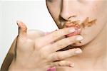 Woman With Chocolate on Her Face, Licking Fingers