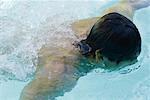 Man swimming in pool, high angle view, close-up