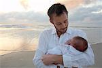 Portrait of Father With Newborn Baby on the Beach