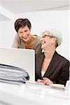 Two women laughing in front of a pc