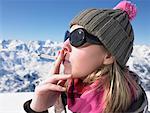 Young woman smoking in snow gear