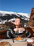 Young woman having breakfast on terrace