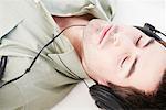 Reclined male relaxes with headphones