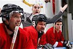 Coach und Hockey-Spieler auf der Bank