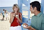 Mature adult couple eating breakfast at beach
