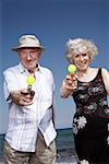 Senior couple on beach with water guns