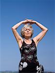 Female senior stretching on beach