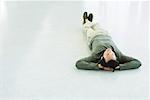 Man lying on the ground, listening to headphones