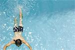 Homme nageant dans la piscine, vue grand angle