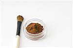Maquillage pinceau et cacao en poudre dans petits contenants de cosmétiques