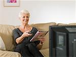 A senior woman watching tv
