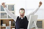 Businessman Sitting at Desk with Self Adhesive Note on Forehead