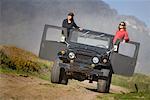 Two Women Standing Up in Four- Wheel Drive Vehicle