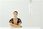 Woman sitting beside wind chime, arms folded, smiling at camera