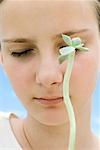 Girl with long stemmed succulent plant, eyes closed