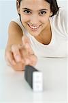 Woman about to set off domino chain reaction, smiling at camera