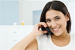 Woman using cell phone, smiling at camera