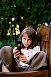 Jeune fille en fauteuil avec téléphone cellulaire