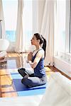 Femme pratiquant de Yoga en Condominium