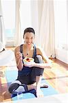 Woman on Yoga Mat with Bowl of Fruit