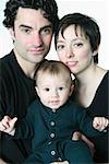 Studio portrait of a family: father, mother and baby boy.