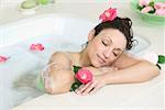 A woman relaxes in a bathtub full of bubbles.