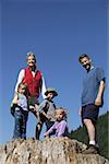 Family posing on a big tree stump.