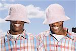 Twin teenage boys in matching hats and shirts.