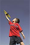 Young boy flying a model airplane.