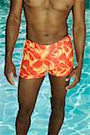 Cropped image of a man standing at poolside.