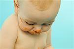 Un bébé avec son visage barbouillé de nourriture pour bébés.