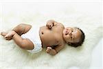 Overhead view of a baby girl on a white fur rug.