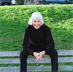 Portrait of a senior woman sitting on a park bench.