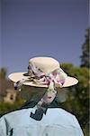 Rear view of a woman wearing a hat with a ribbon.