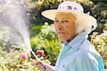 Senior woman watering her garden.