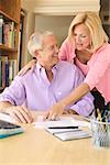 Couple working on paying bills in a home office.