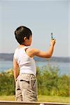 Young boy taking a photo with his mobile phone