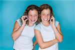 Teenaged twins using mobile phones