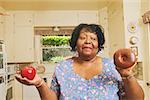 Woman deciding whether to eat an apple or doughnut