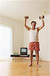 Middle-aged man lifting weights at home