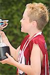 Profile of a boy holding a trophy