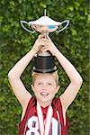 Boy balancing a trophy on his head