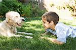 Boy and dog facing each other