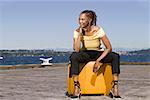 Femme assise en plein air sur la valise
