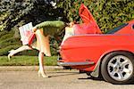 Woman looking in trunk of car