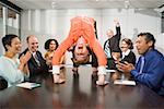 Businesswoman doing backbend at meeting