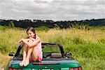 Portrait of girl sitting on car