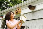 Smiling woman adding to birdhouse collection