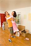 Couple embracing in neues Zuhause mit Boxen