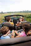 Family in convertible using portable electronics